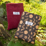 Protège livre grand format personnalisable en velours côtelé bordeaux, posé en extérieur.